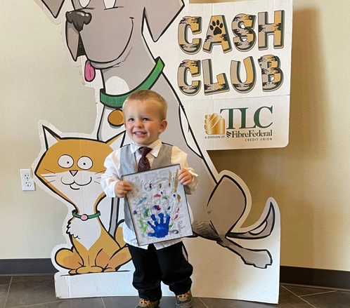 Kid holding art for cash club