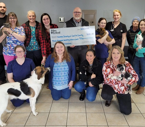 Group of people holding a large donation check